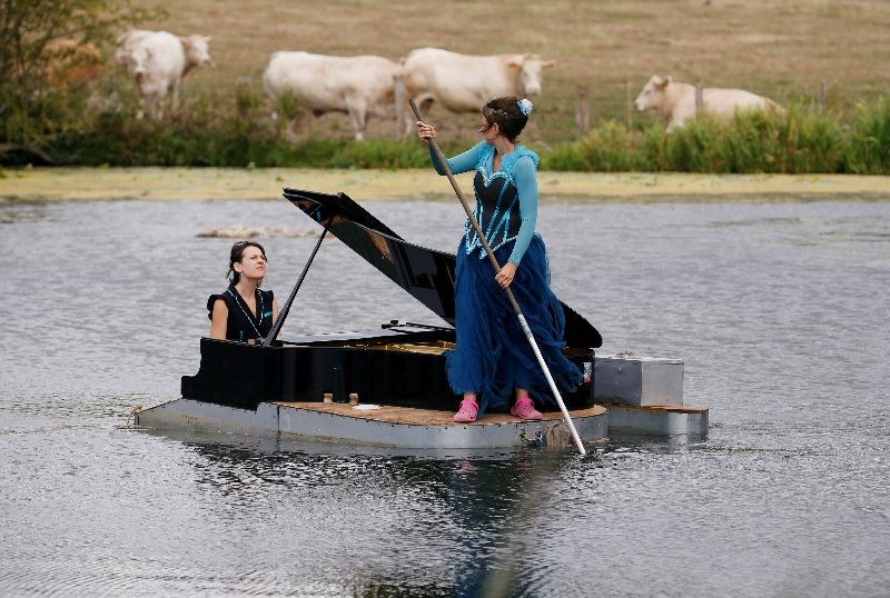 Pianist Cecile Wouters and singer Evelyne Zou perform on a lake during a rehearsal of their show a Melting Flotte at the Chateau de Ricquebourg in Ricquebourg, France. (Photo by Pascal Rossignol/Reuters)
